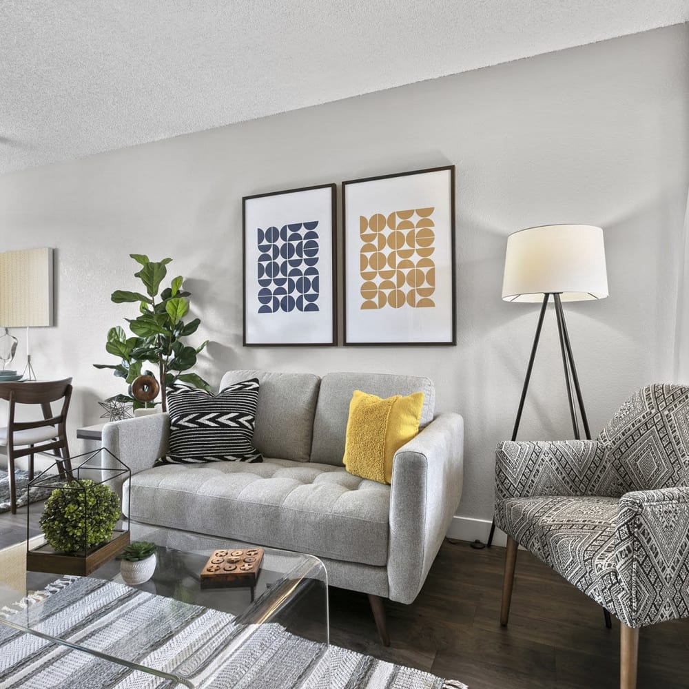 Living space with wood-style flooring at Casitas Apartments in Ontario, California