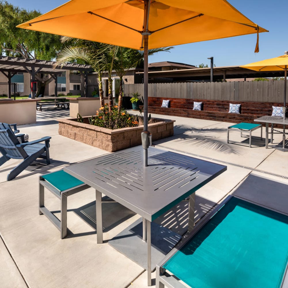 Table and chairs with an umbrella at Amara Apartments in Santa Maria, California