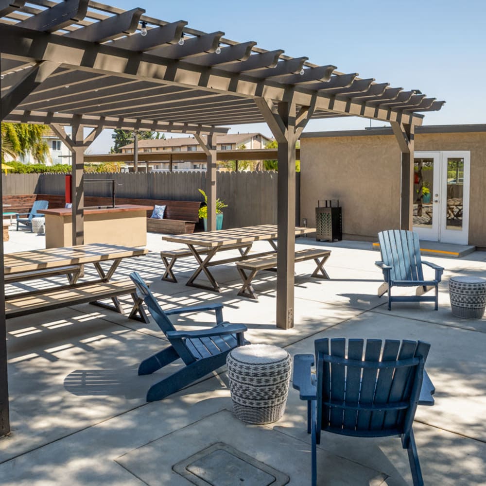 Covered picnic tables with additional patio chairs at Amara Apartments in Santa Maria, California