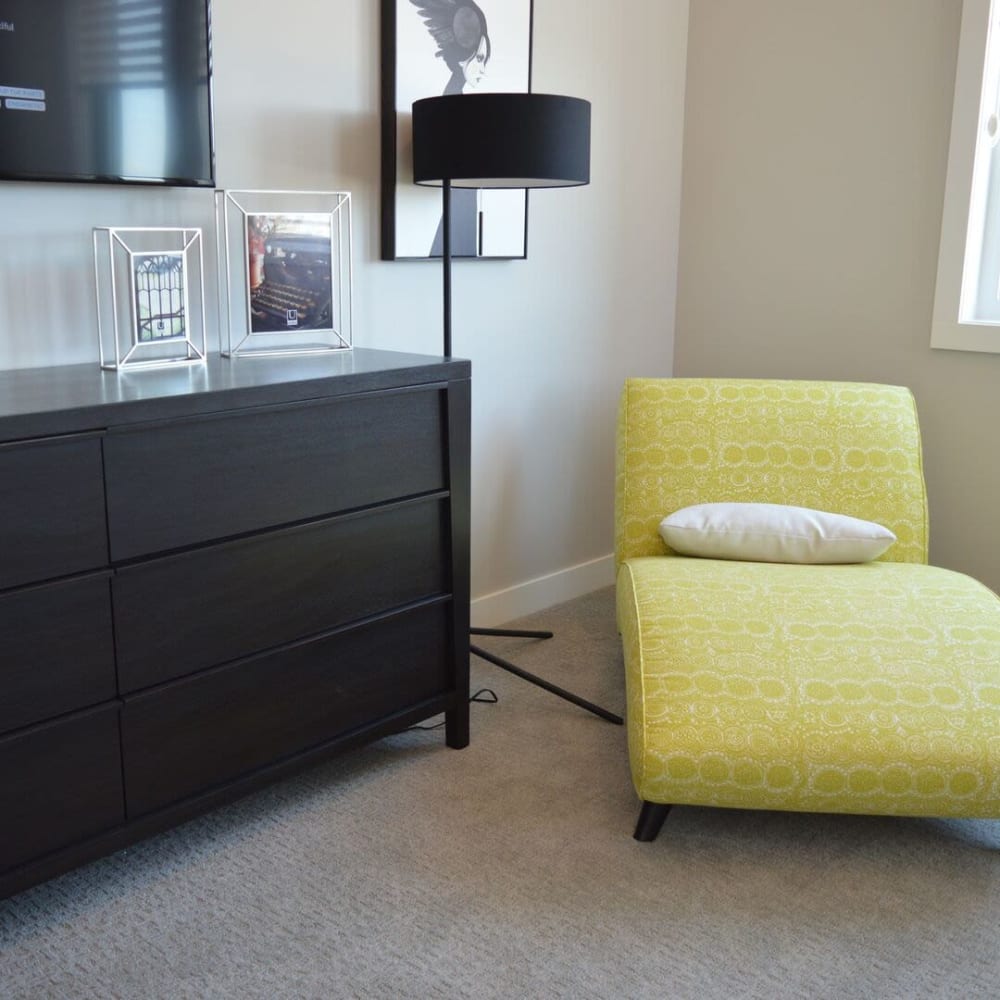 A lounge chair and dresser in an apartment at Brighton Park Apartments in Salt Lake City, Utah