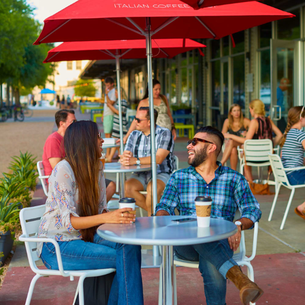 sidewalk seating with cafe tables and umbrellas near Harvest Lofts in Dallas, Texas