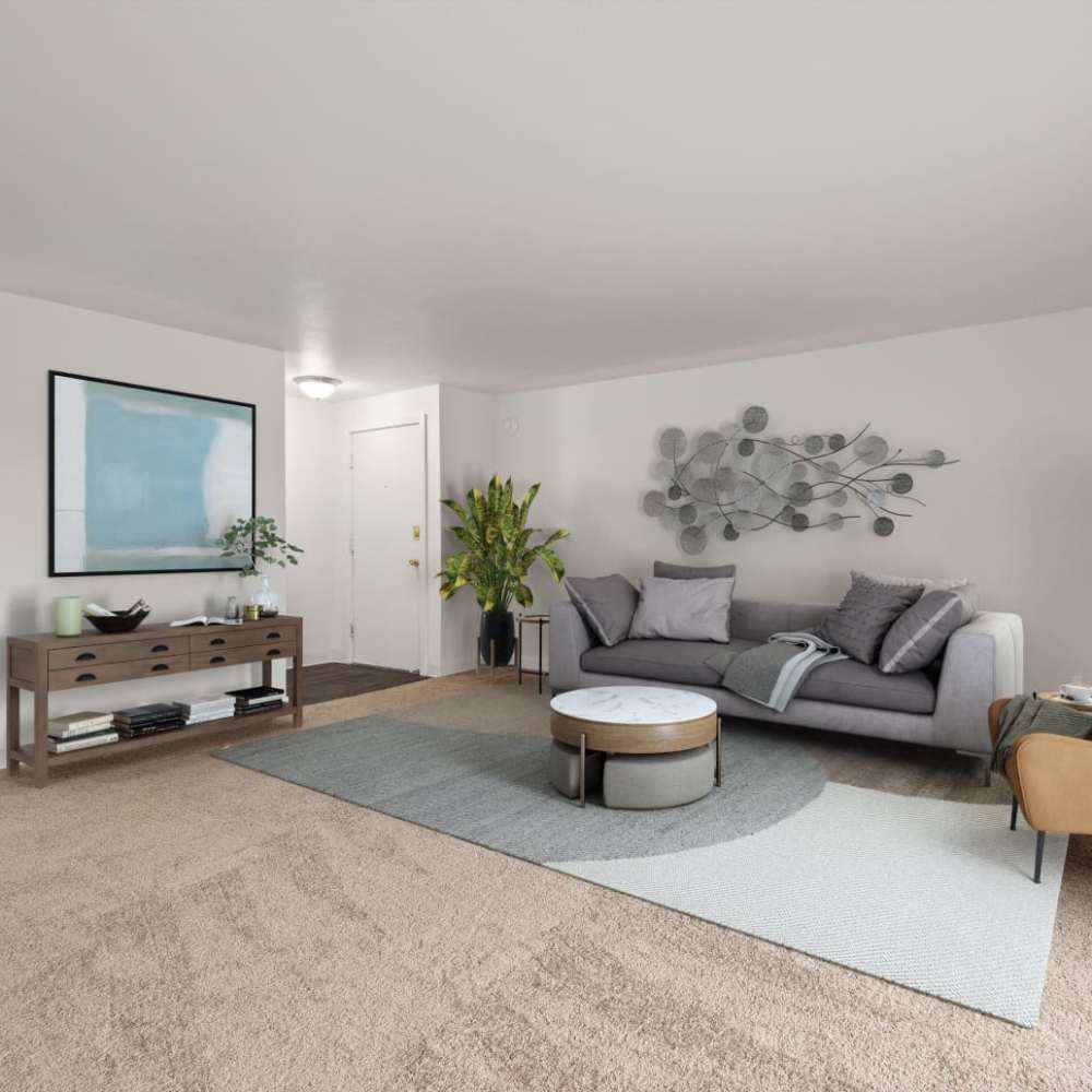 Model living room with plush carpeting at Bluffs at Evergreen in Everett, Washington