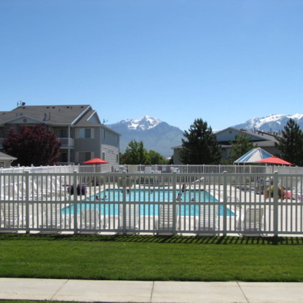The swimming pool with a view of the mountains in the background at Stonebridge Apartments in West Jordan, Utah