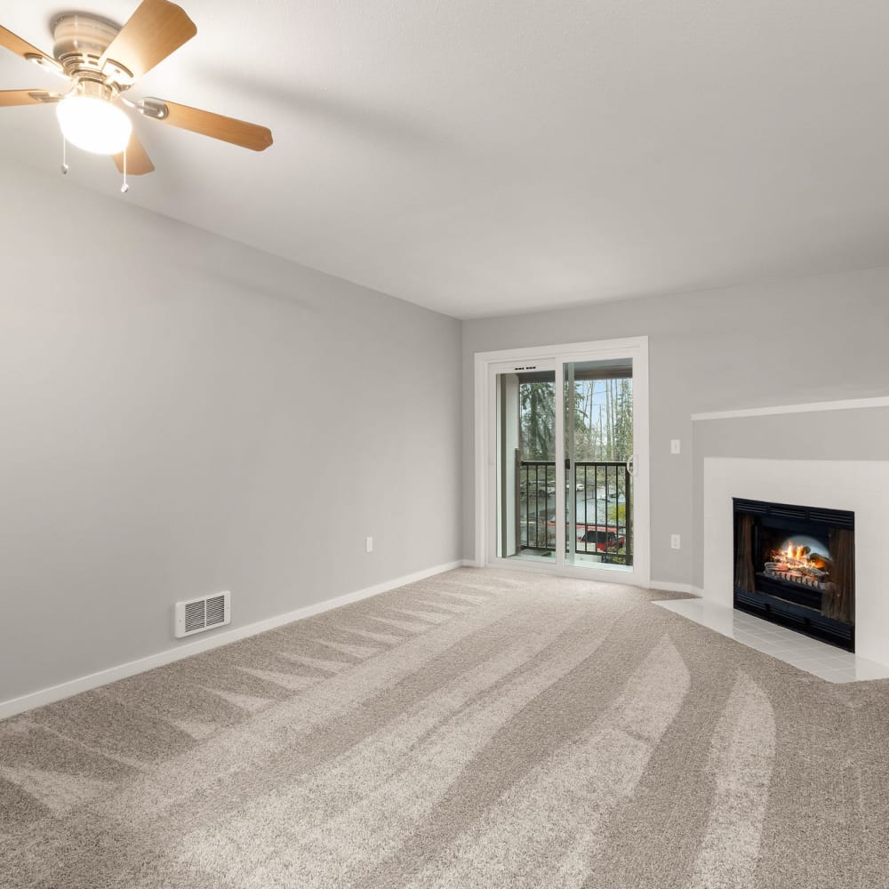 Living room with slider door and ceiling fan at The BLVD in Kent, Washington