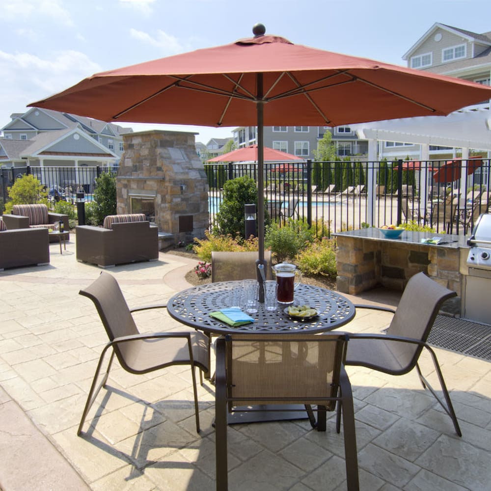 Patio table with an umbrella and chairs at The Preserve at Cohasset in Cohasset, Massachusetts