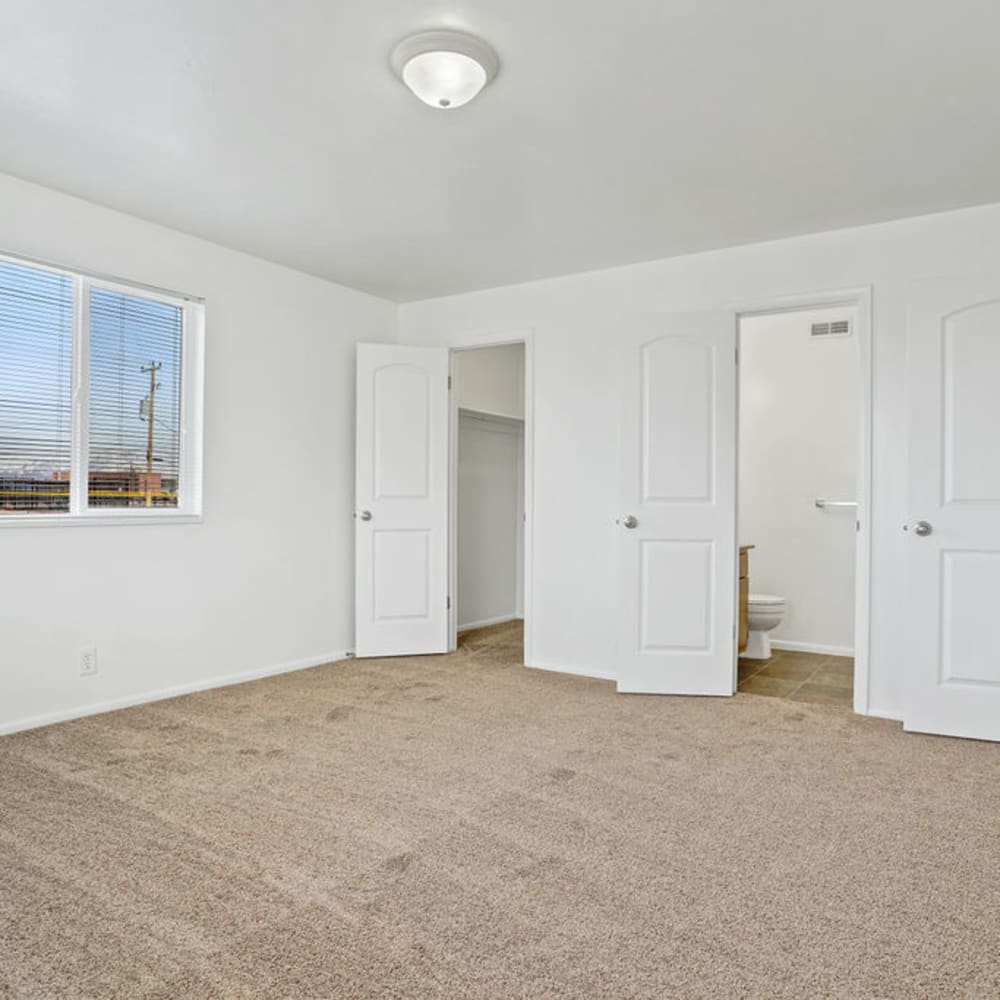 A main bedroom with an attached bathroom and walk-in closet at Chadds Ford Apartments in Midvale, Utah