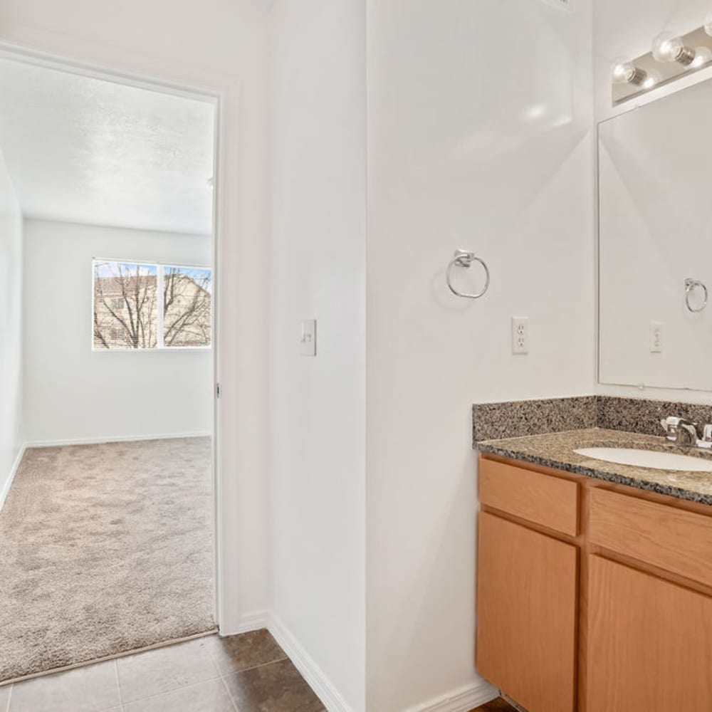A bathroom attached to a large bedroom at Clinton Towne Center Apartments in Clinton, Utah