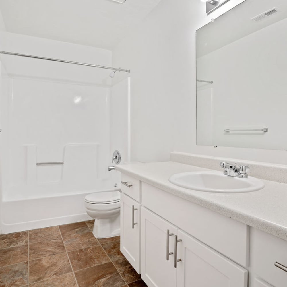 White cabinets and tile flooring in an apartment bathroom at Highland Pointe Apartments in Cottonwood Heights, Utah