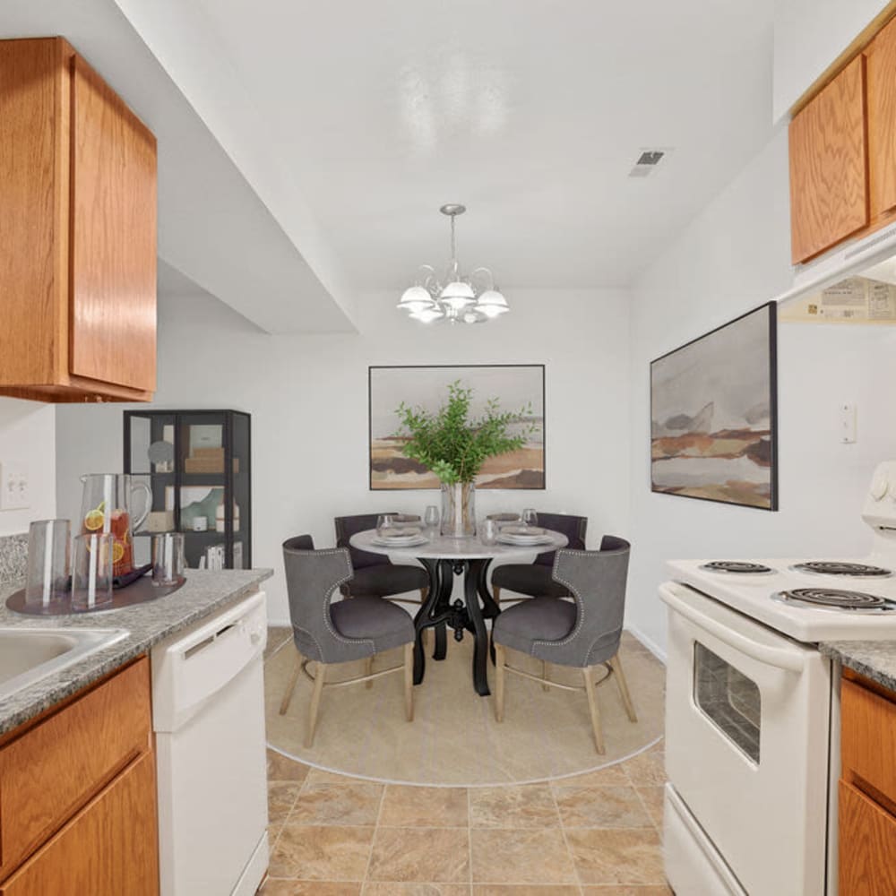An apartment kitchen with a furnished dining room at Highland Pointe Apartments in Cottonwood Heights, Utah