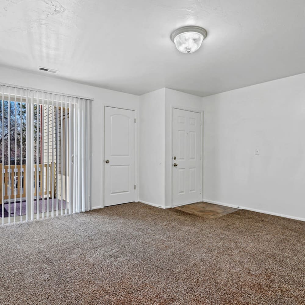 Plush carpeting and a sliding door to the patio in an apartment at Mallard Crossing Apartments in Millcreek, Utah