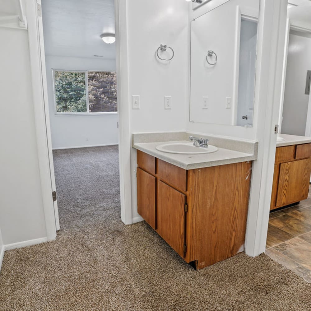 A sink in an apartment bathroom attached to a bedroom at Mallard Crossing Apartments in Millcreek, Utah