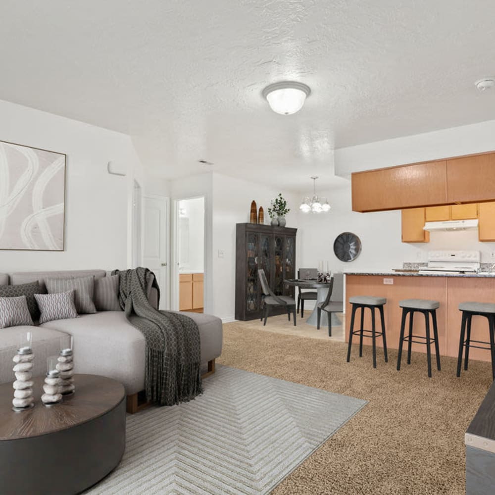 A furnished apartment living room and bar seating in the kitchen at Stonebridge Apartments in West Jordan, Utah
