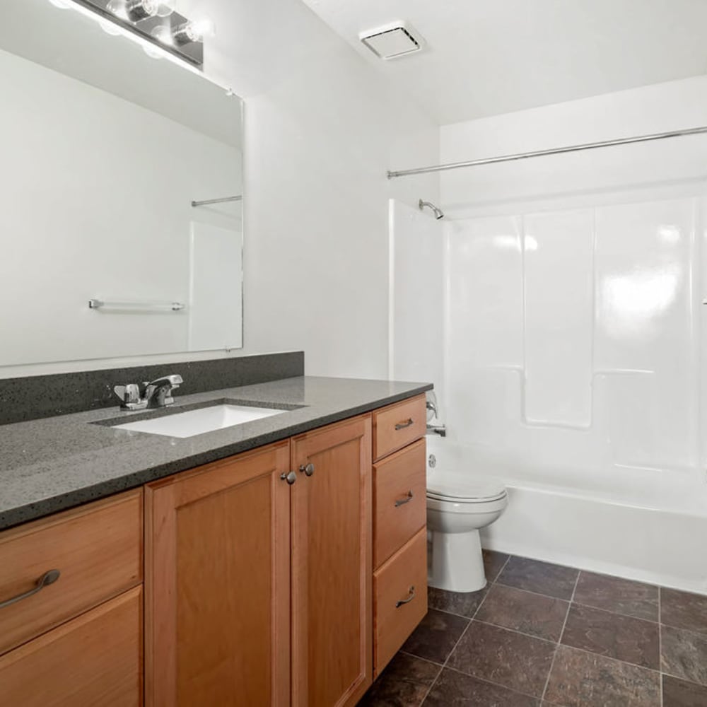 A large countertop and a full-sized bathtub in an apartment bathroom at Valley Park Apartments in Salt Lake City, Utah
