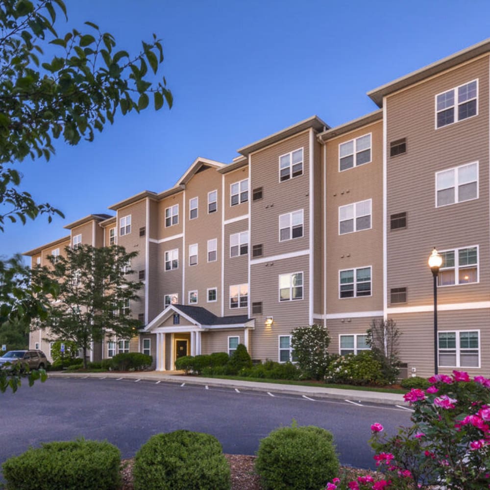 Apartment building exterior in the evening at Lux at Stoughton in Stoughton, Massachusetts