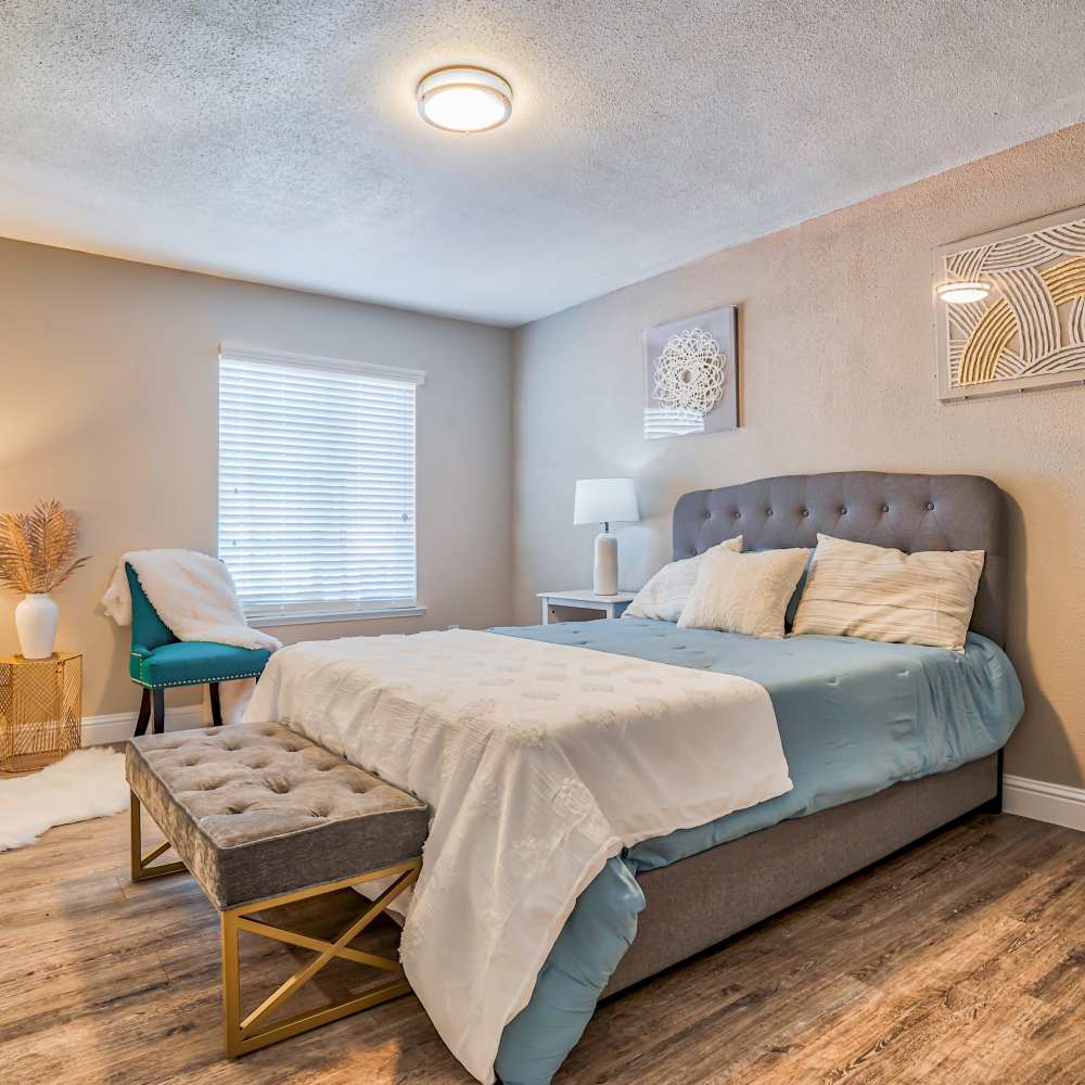 Bed with blue cover at Ascent Townhome Apartments in Fresno, California