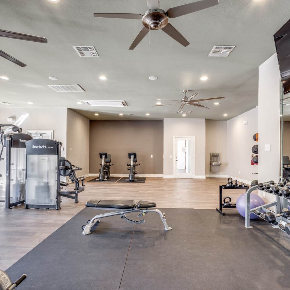 Fitness center with free-weights at Oak Crest in Houston, Texas