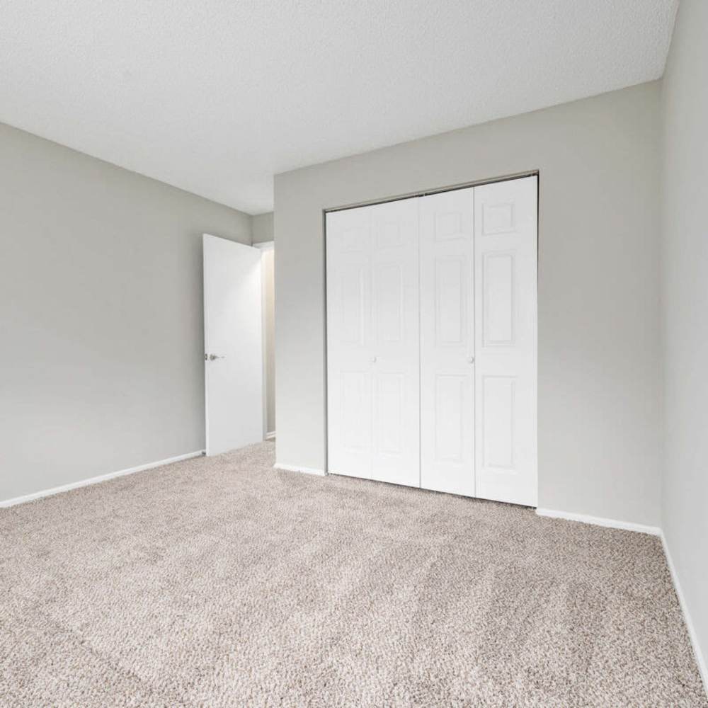 Bedroom with plush carpeting at Concord Apartments in Raleigh, North Carolina