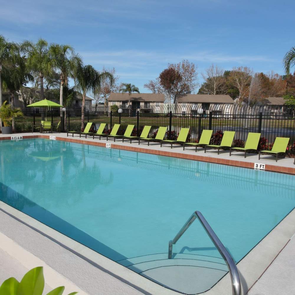 Swimming pool surrounded by lounge chairs at Four Lakes at Clearwater in Clearwater, Florida