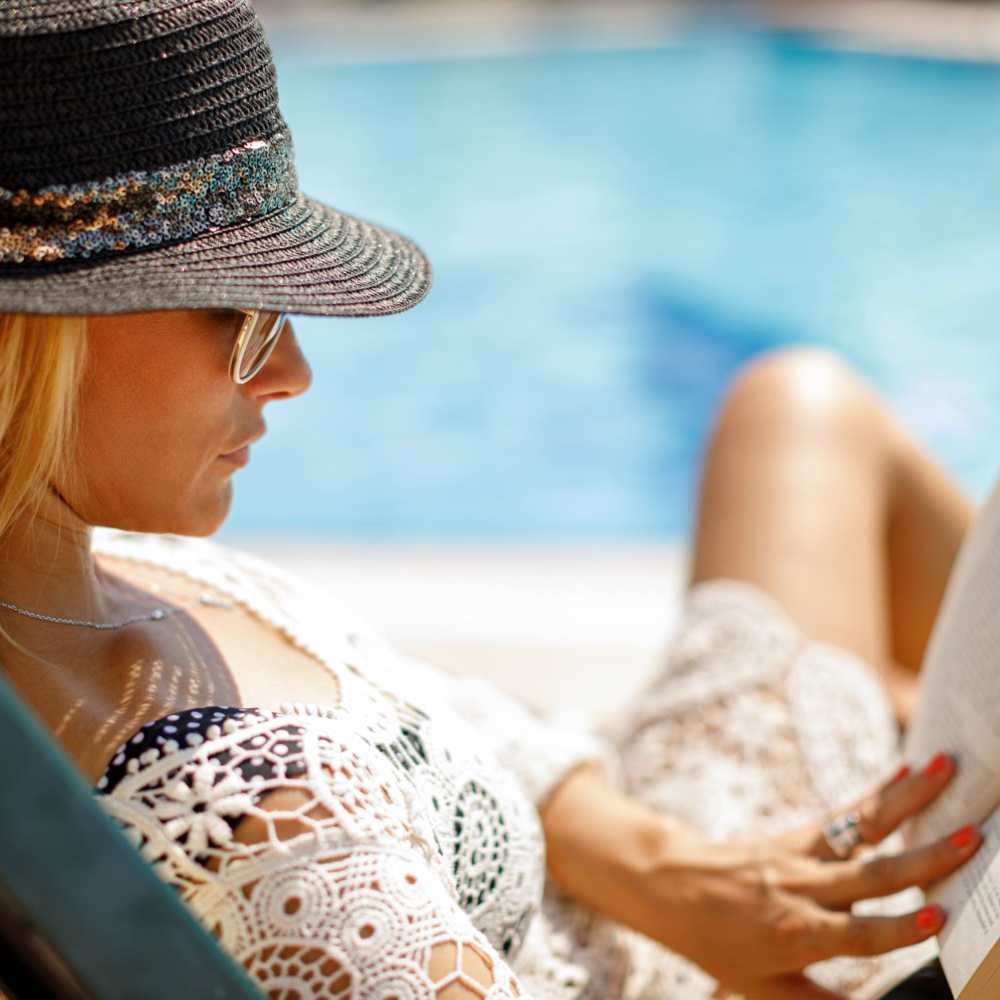 Resident reading book by pool at Bella Vista in Napa, California
