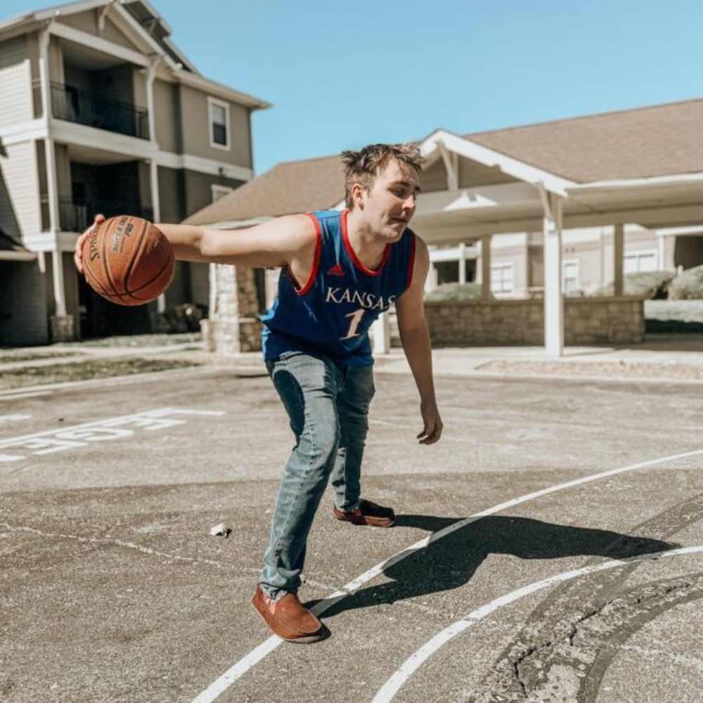 Resident playing basketball at The Quarters at Lawrence in Lawrence, Kansas