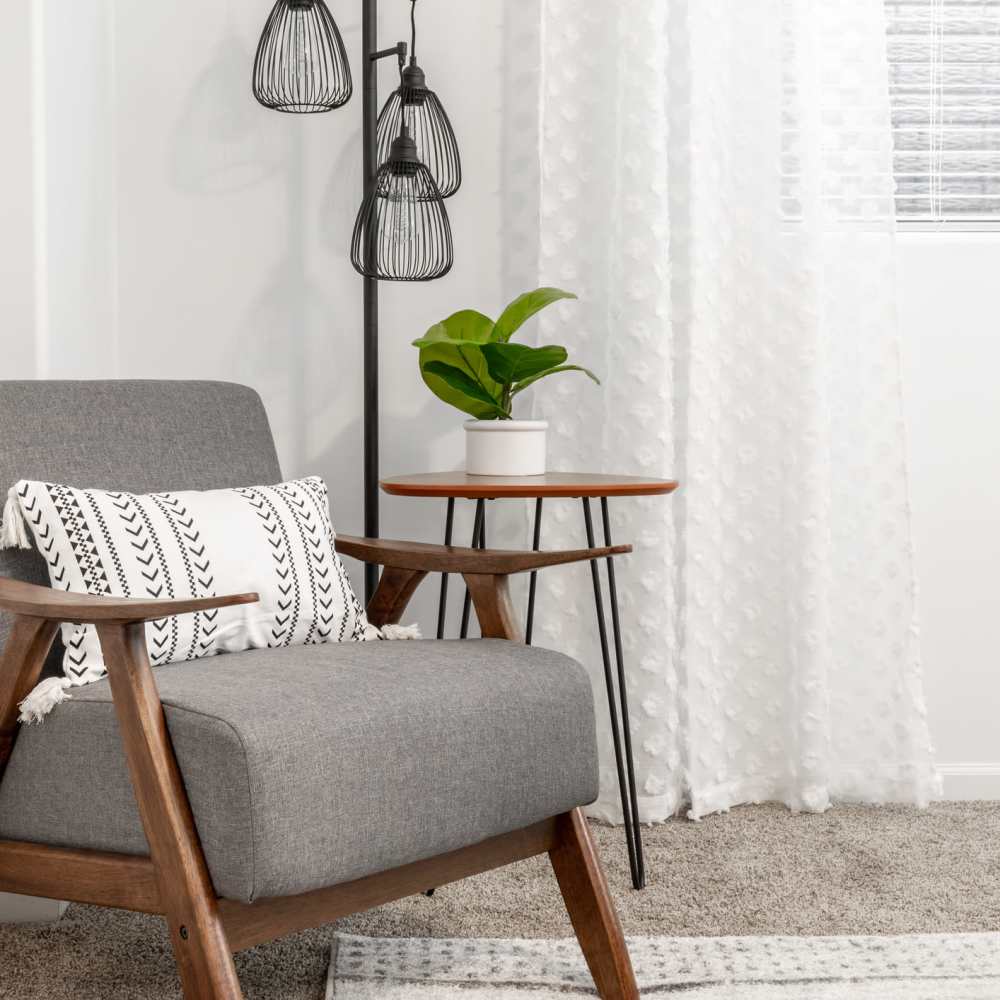 Chair by a side table and a lamp at The Elysian at Stonefield in Charlottesville, Virginia