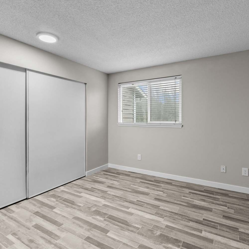 Bedroom with wood-style flooring at Spinnaker Apartments in Des Moines, Washington