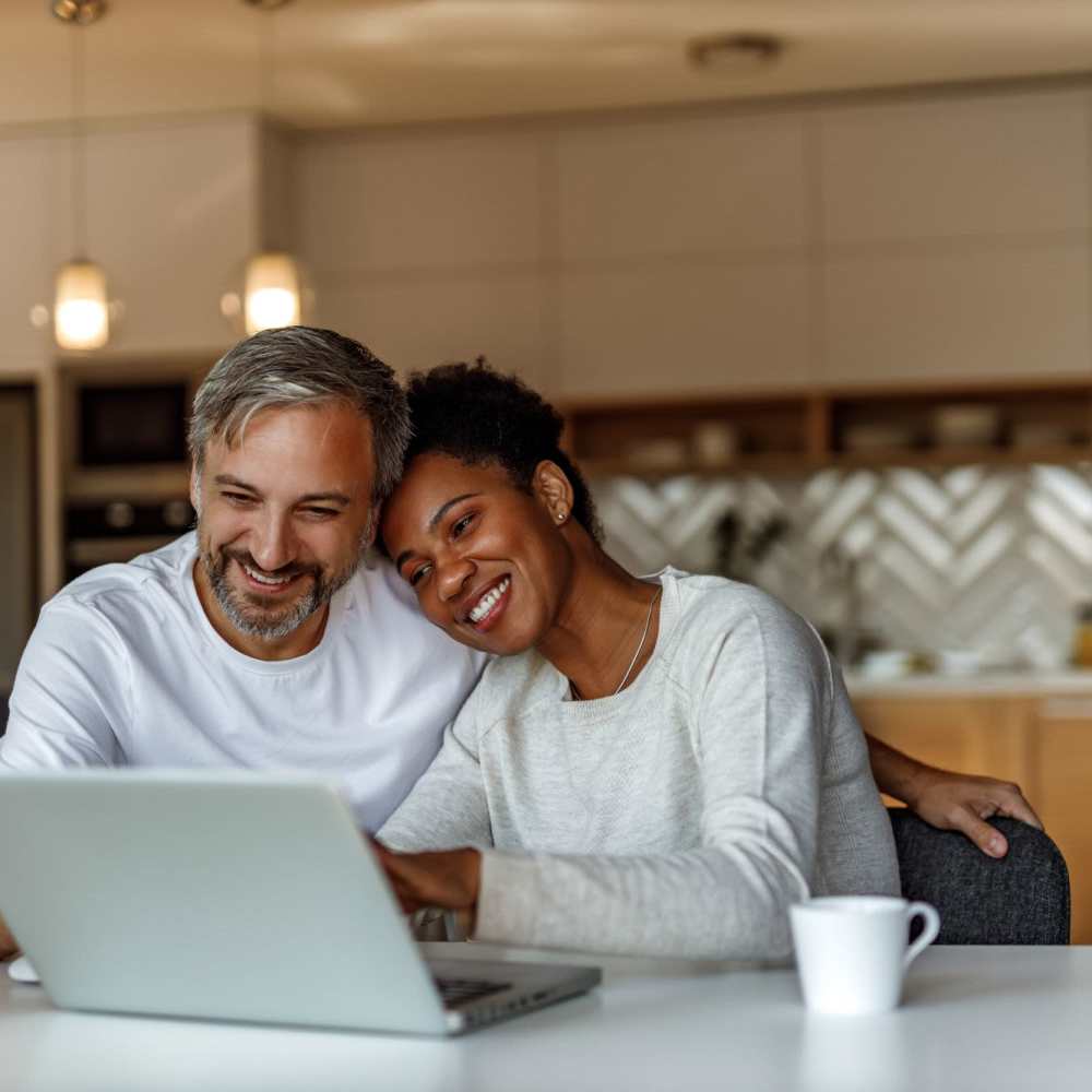 Happy couple checking their laptop at 353 Main Street Family Apartments in Redwood City, California