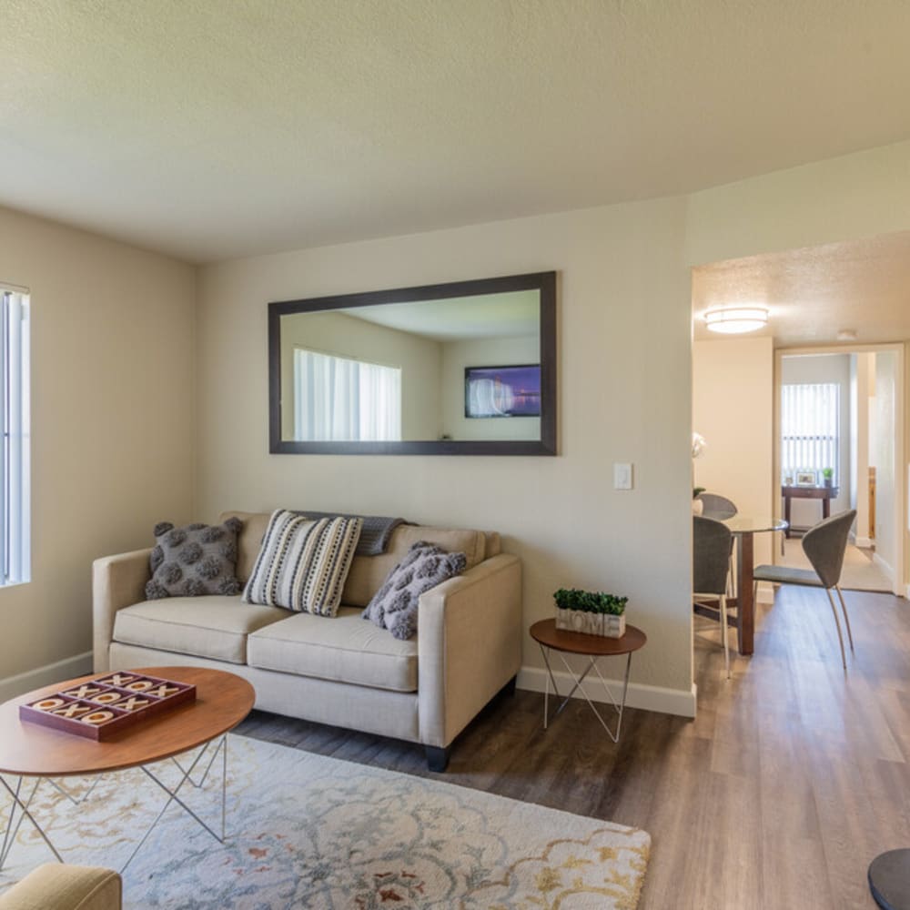 View of the living room with cozy chairs and tables in Riverstone Apartments in Sacramento, California