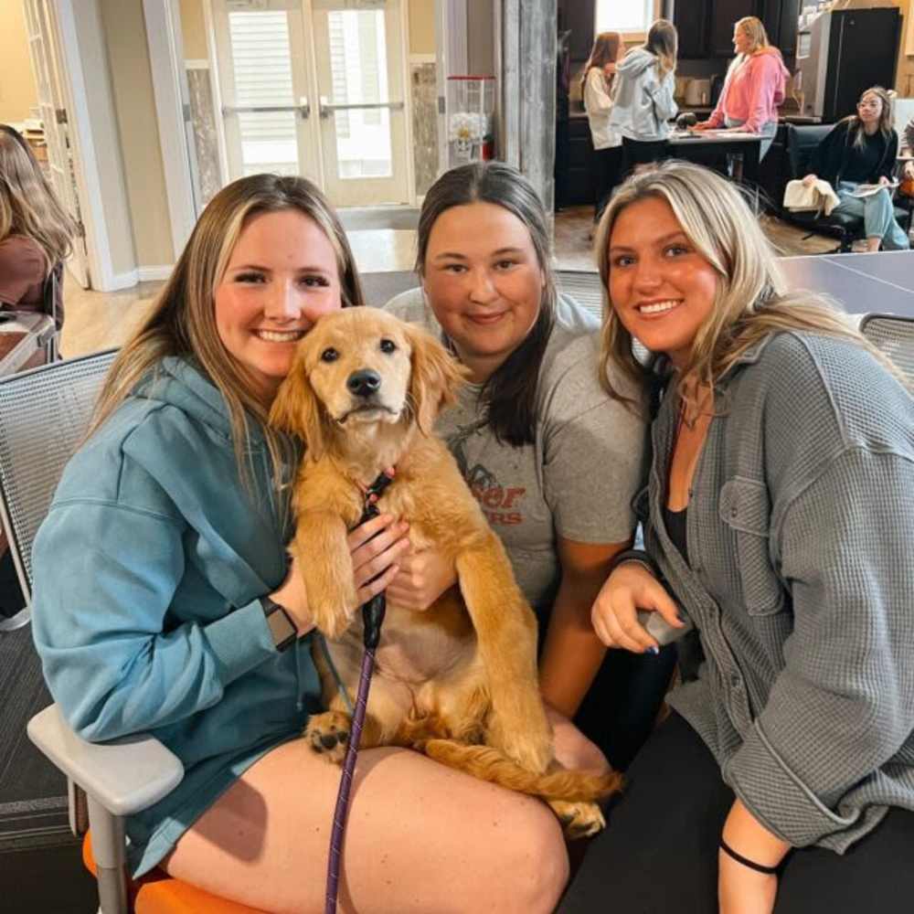 Residents with golden retriever puppy at College Town Mankato in Mankato, Minnesota