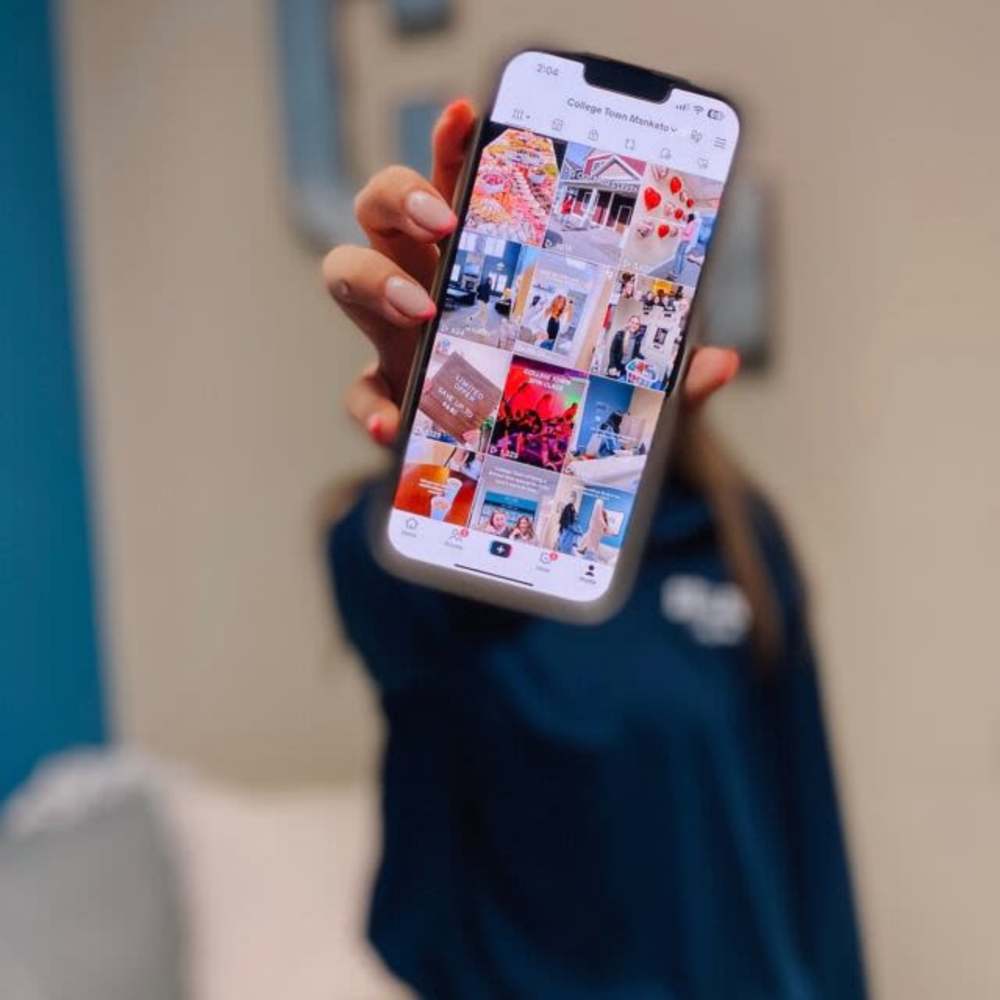 Resident with cell phone showing instagram feed at College Town Mankato in Mankato, Minnesota