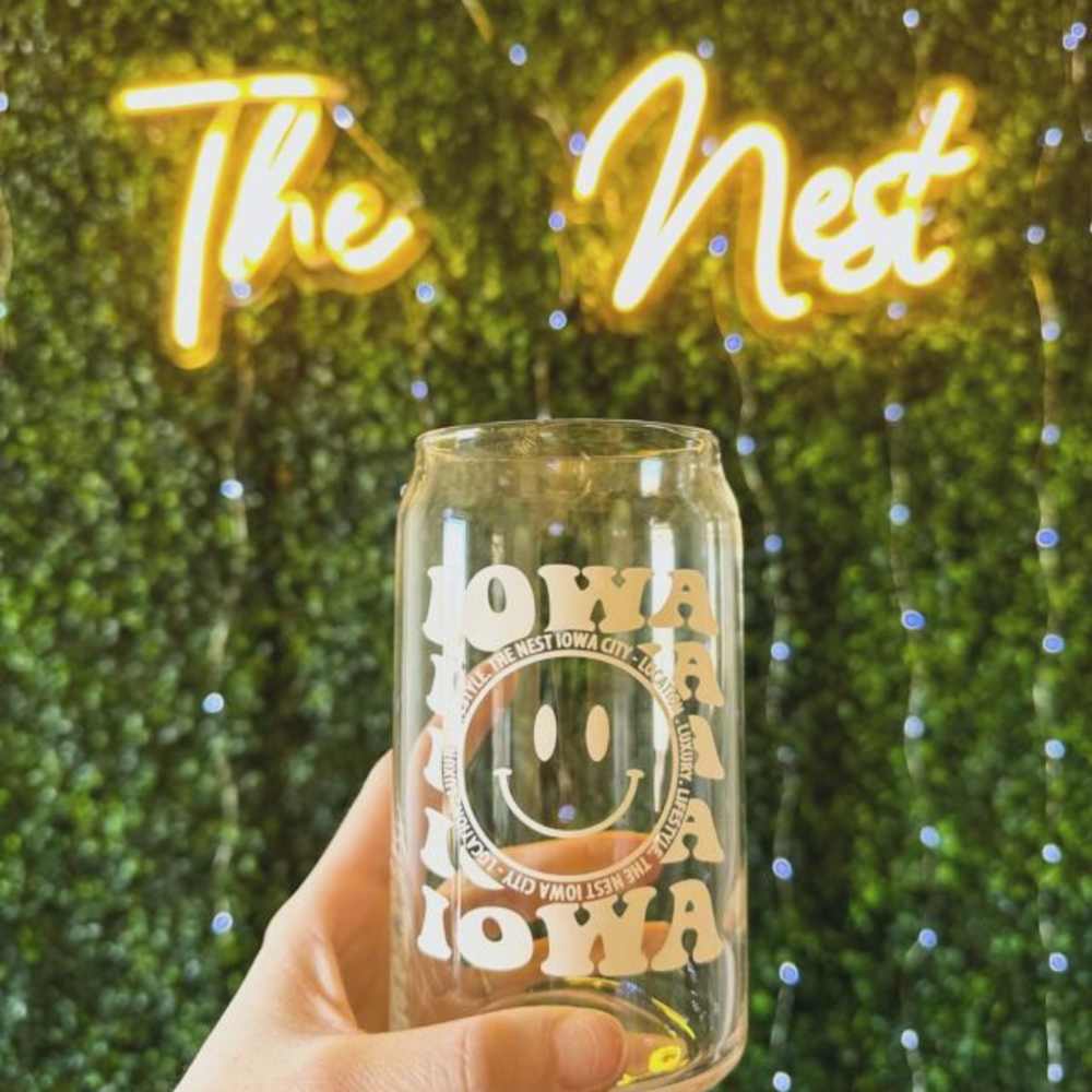Promotional cup in front of neon sign at The Nest in Iowa City, Iowa