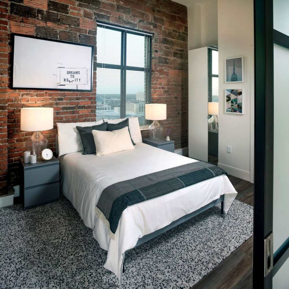 Modern-style bed and nightstand at The Residences at Barnett in Jacksonville, Florida