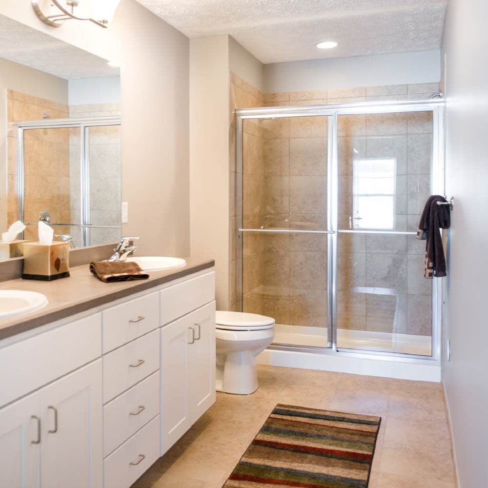 Spacious bathroom with walk-in shower and sink at Fairways Villas II Apartments in Victor, New York