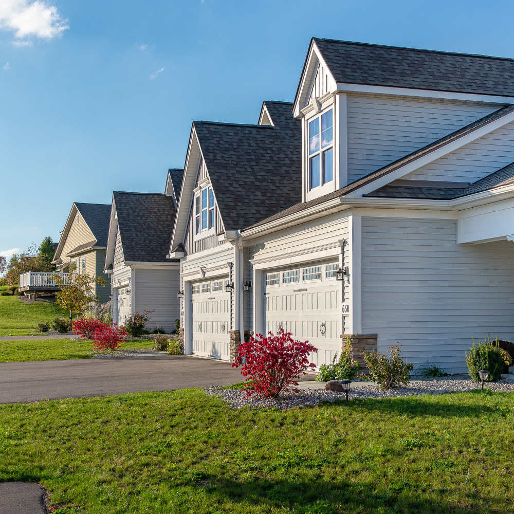 Residential homes with attached garages and beautiful landscape yards at Fairways Villas II Apartments in Victor, New York