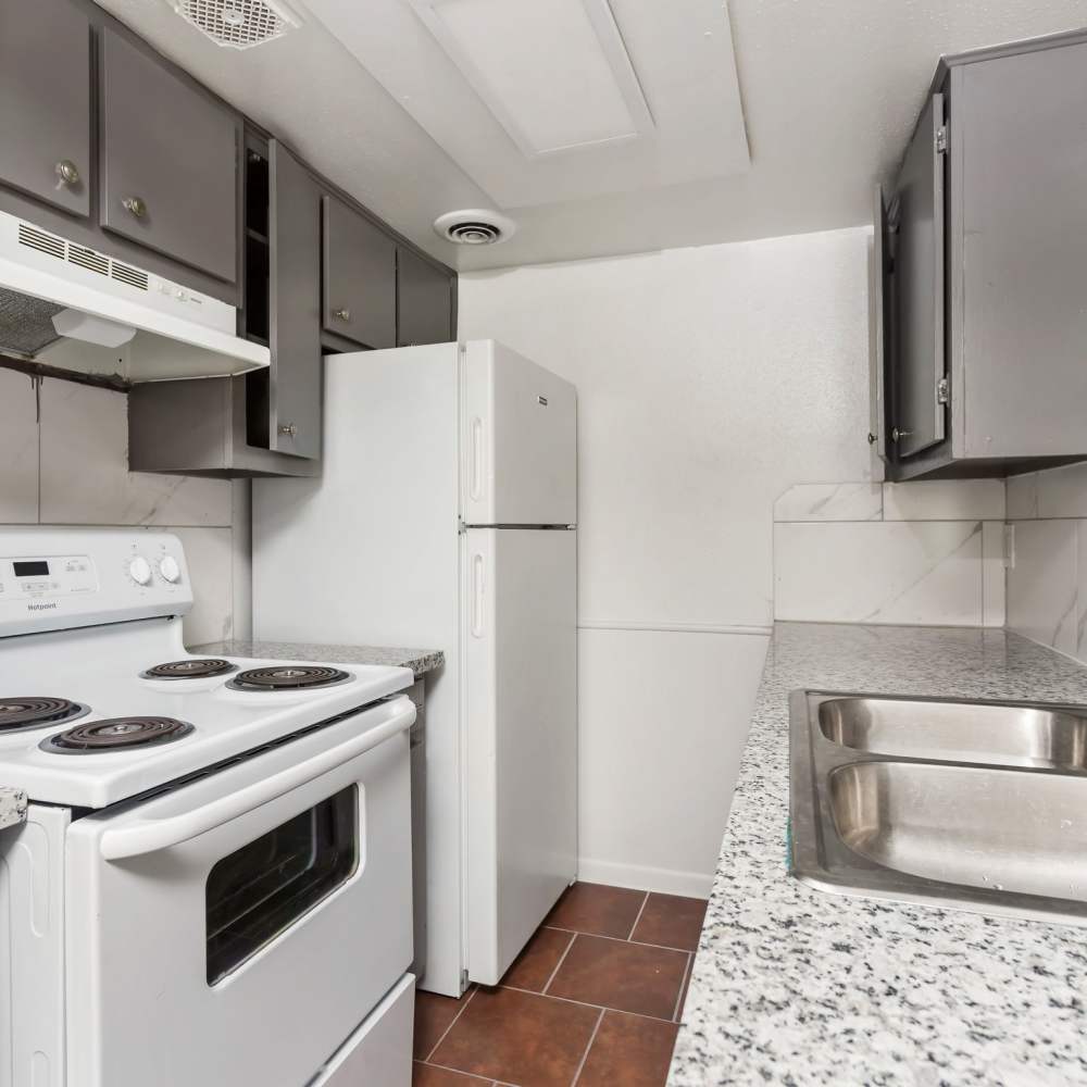 Kitchen with white appliances at Las Rocas in Houston, Texas