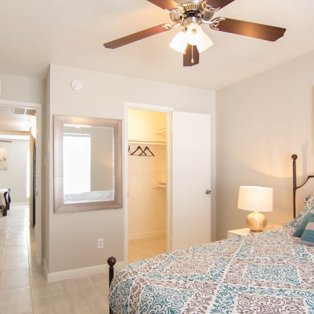 Spacious bedroom with attached closet area and a large mirror at Villa Barcelona in Houston, Texas