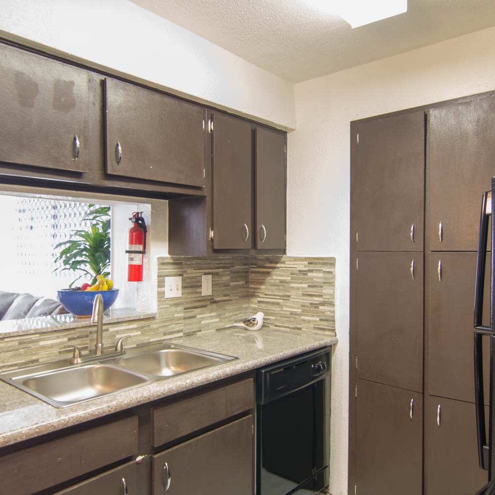 Fully furnished kitchen with stainless-steel appliances and a refrigerator at Villa Barcelona in Houston, Texas