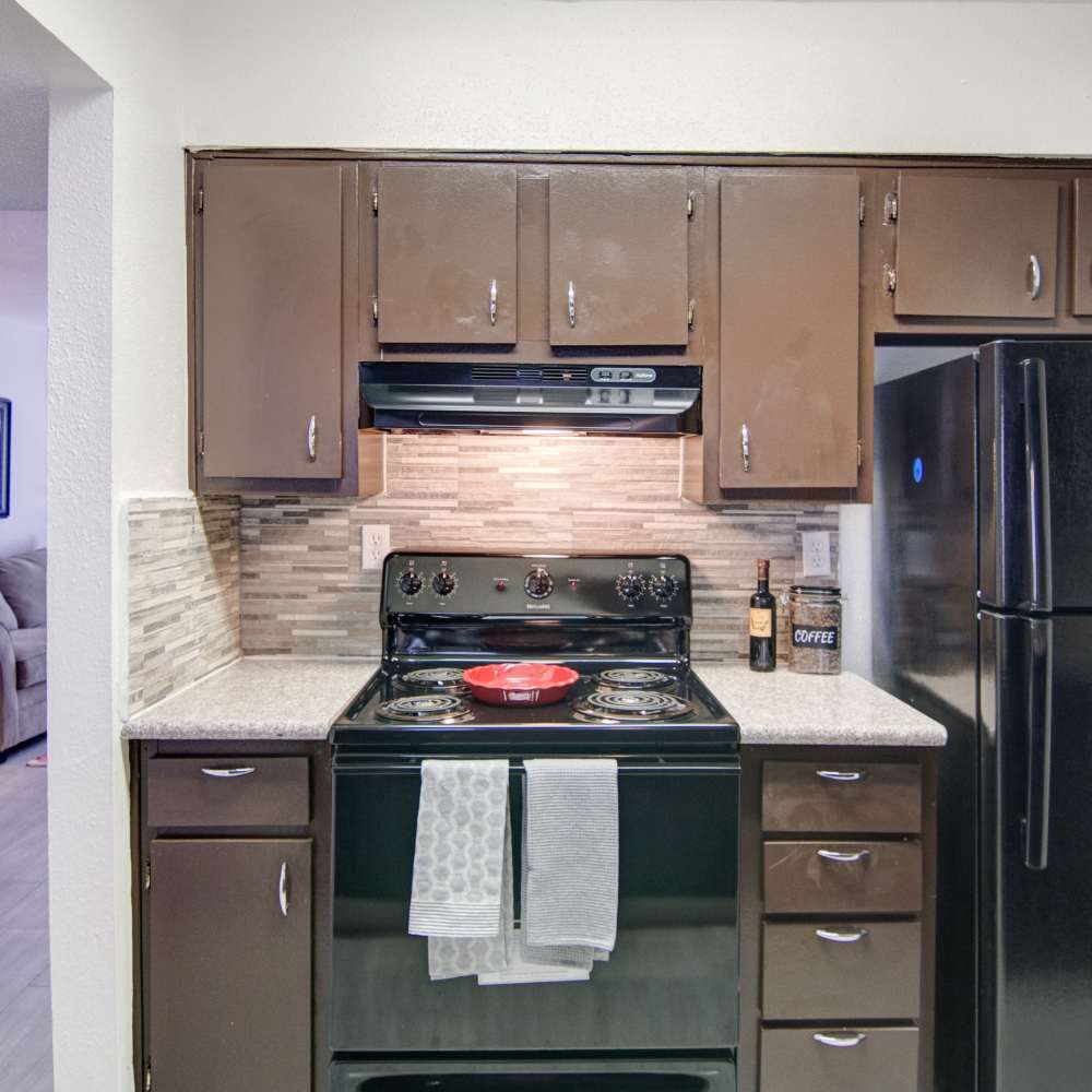 Modern kitchen with wooden storage units and granite countertops at Villa Barcelona in Houston, Texas