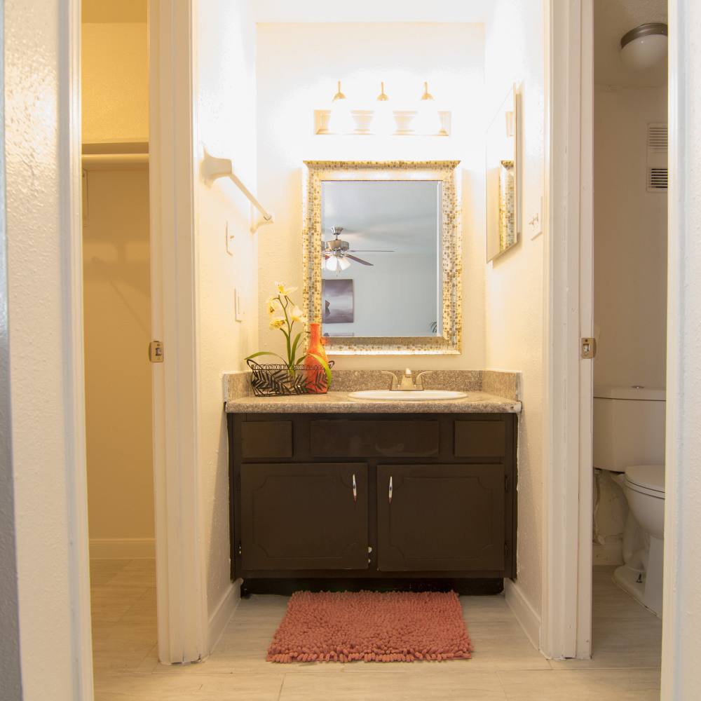 Bathroom with a large mirror and granite countertops at Villa Barcelona in Houston, Texas