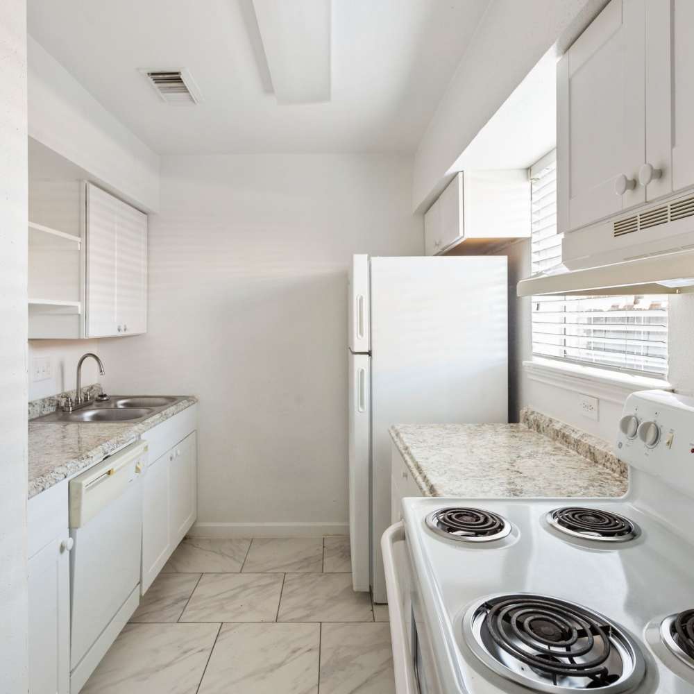 Kitchen with white appliances at La Carmona in Houston, Texas