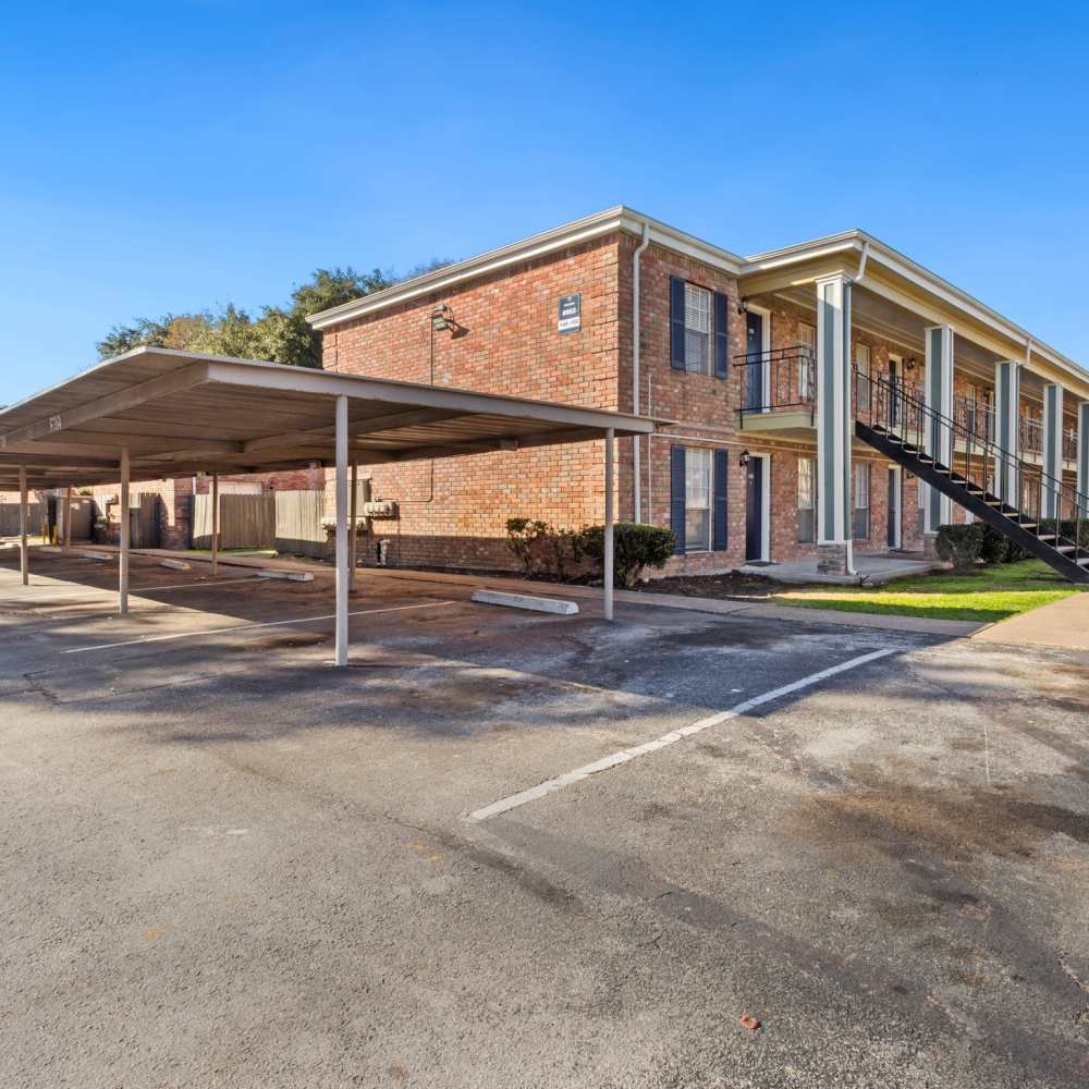 External view of apartment building with carports at La Carmona in Houston, Texas