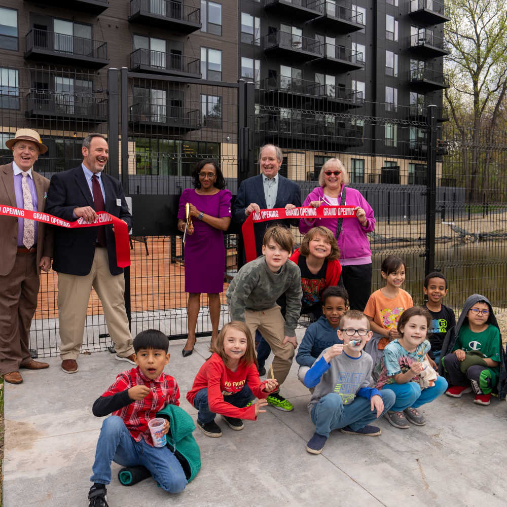 Kids and event organizer on a ribbon cutting in The Eloise at Wirth on the Woods in Minneapolis, Minnesota
