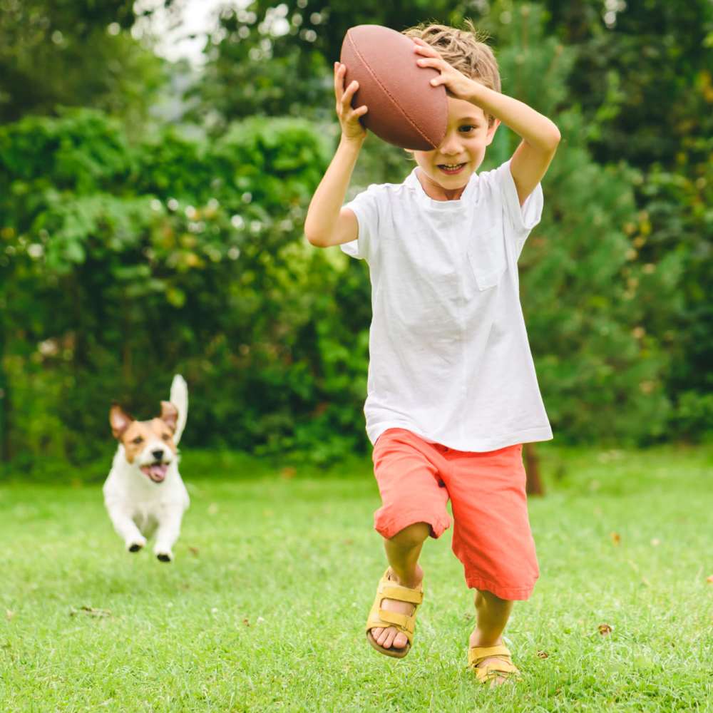 Child playing in a field with a dog 354 Seton Grove in South Orange, New Jersey