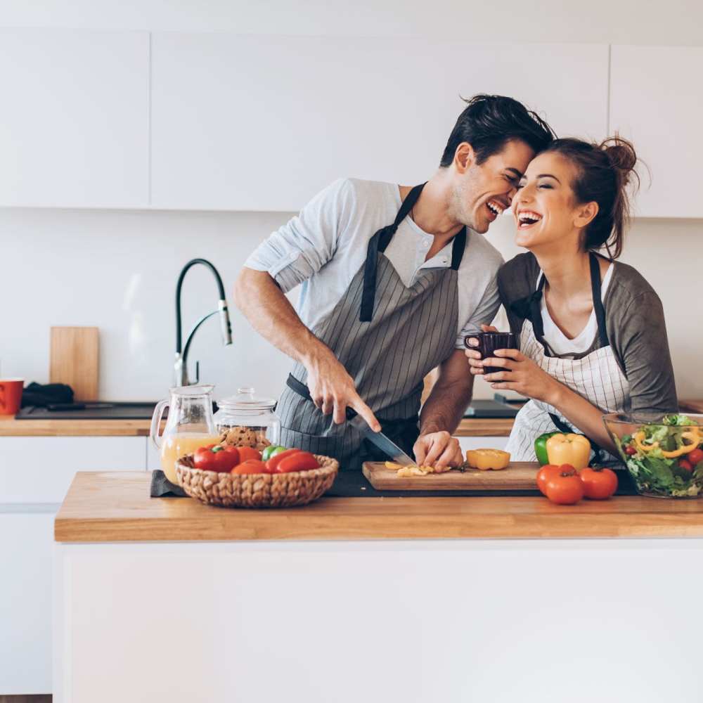 Happy couple cooking in kitchen at Lake House in Los Angeles, California
