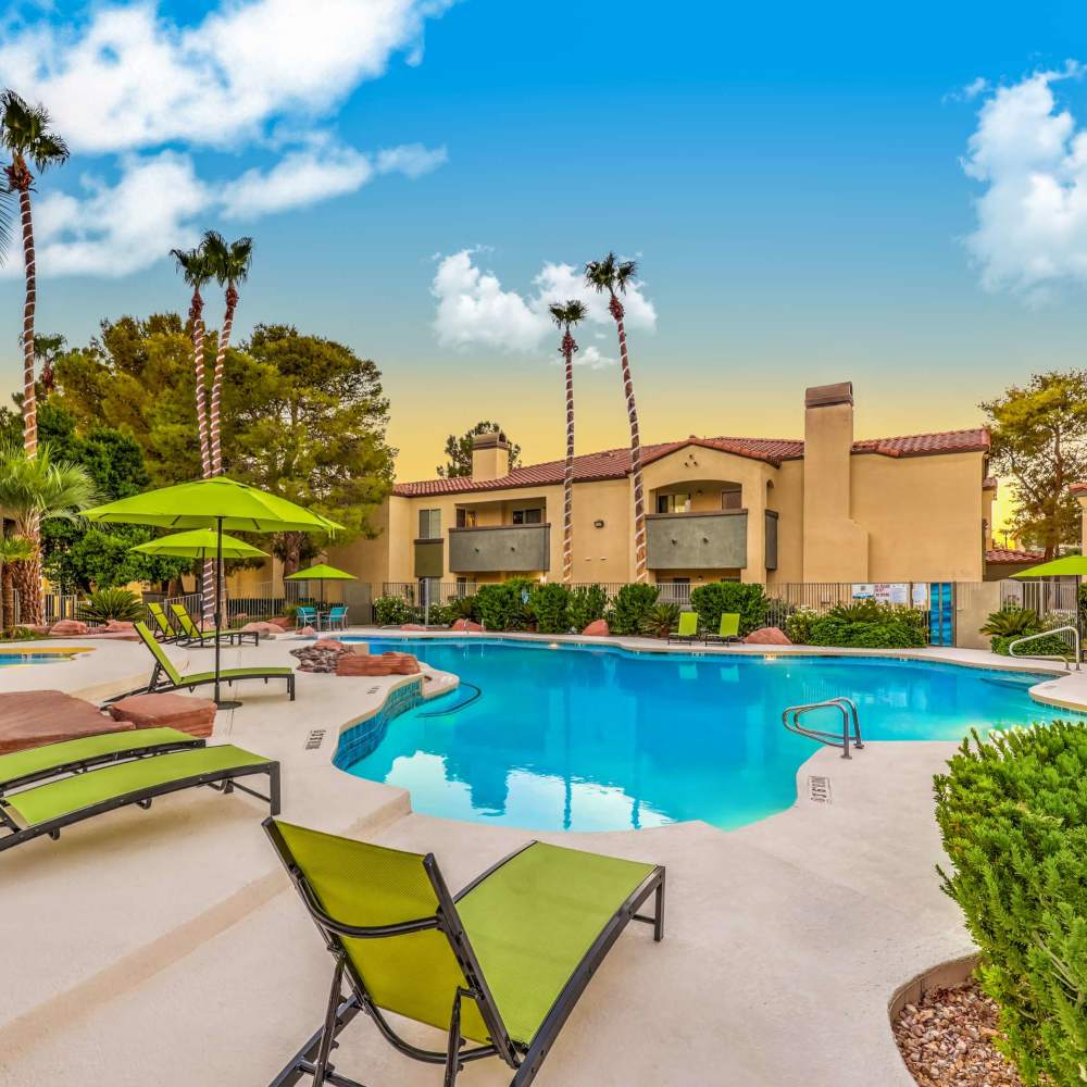 Swimming pool surrounded by lounge chairs at Parkway Townhomes in Henderson, Nevada