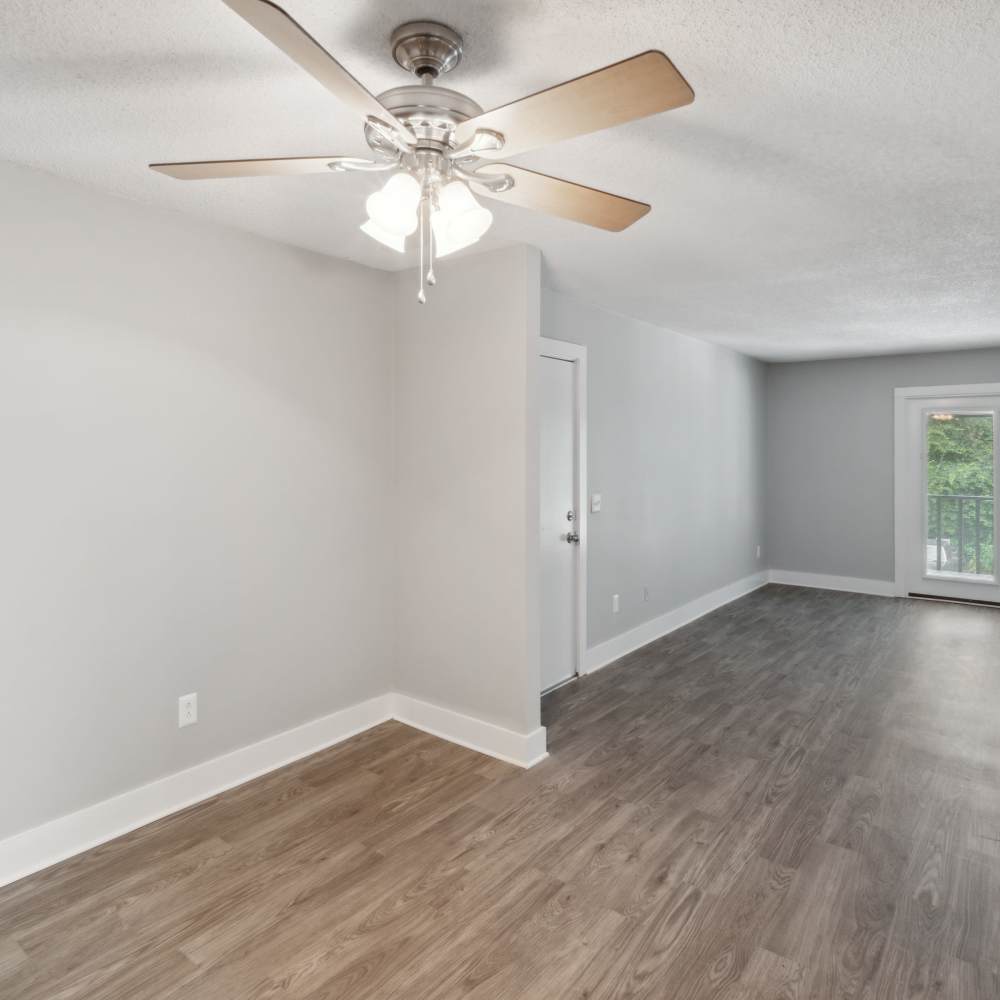 Empty living room showing the beautiful flooring and fancy ceiling fan at Nottingham Apartments in Hendersonville, Tennessee