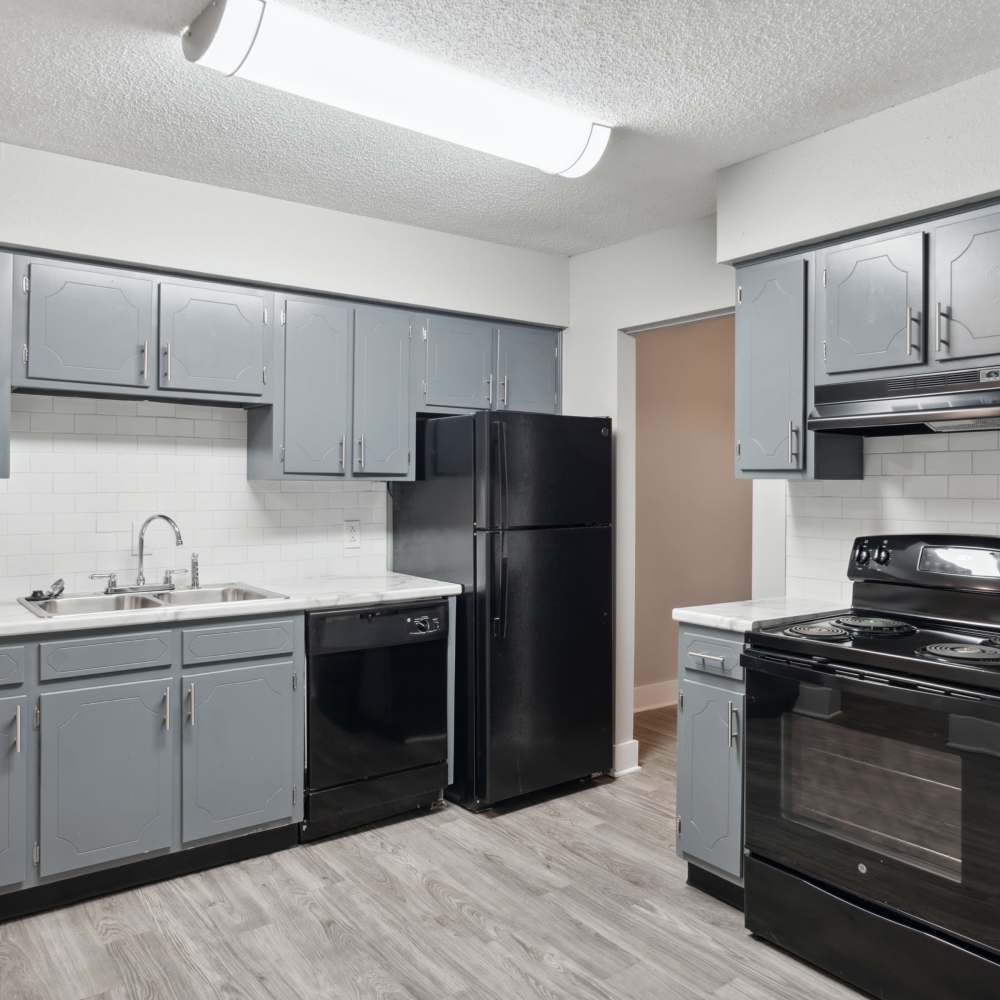 Beautiful kitchen with wood-style flooring, latest appliances and gray cabinetry at Nottingham Apartments in Hendersonville, Tennessee