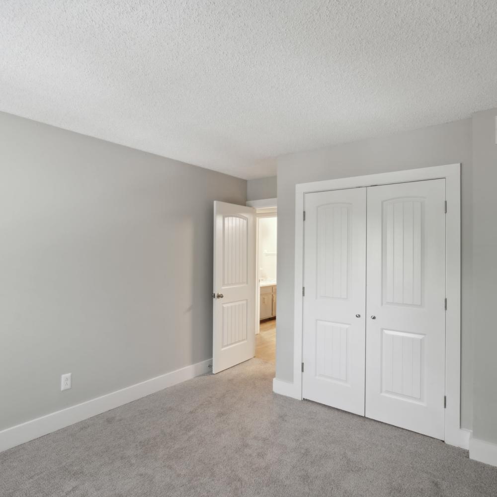 Empty bedroom with a walk-in closet and plush carpet flooring at Nottingham Apartments in Hendersonville,Tennessee