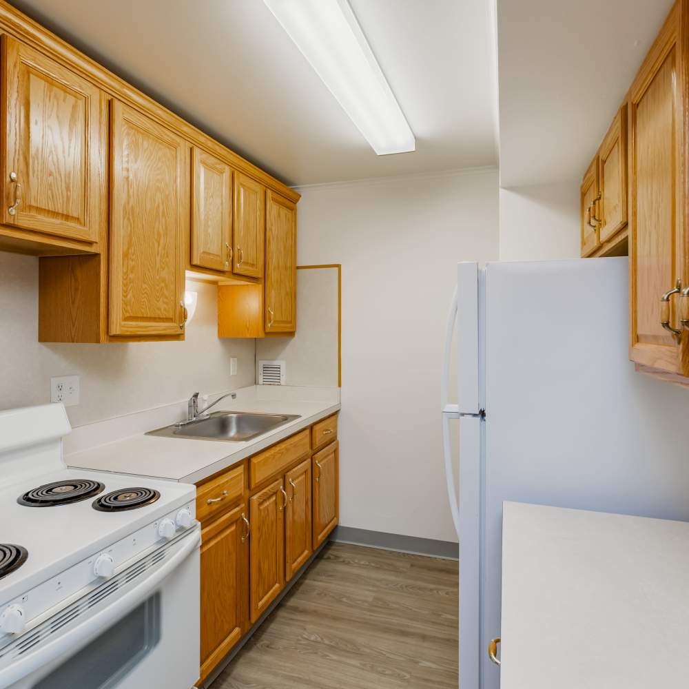 Fully equipped kitchen with natural wood cabinets at Perrytown Place in Pittsburgh, Pennsylvania