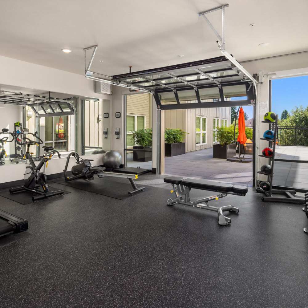 Resident working out with cowbell weight at gym at Sixth & Alder Apartments in Tacoma, Washington